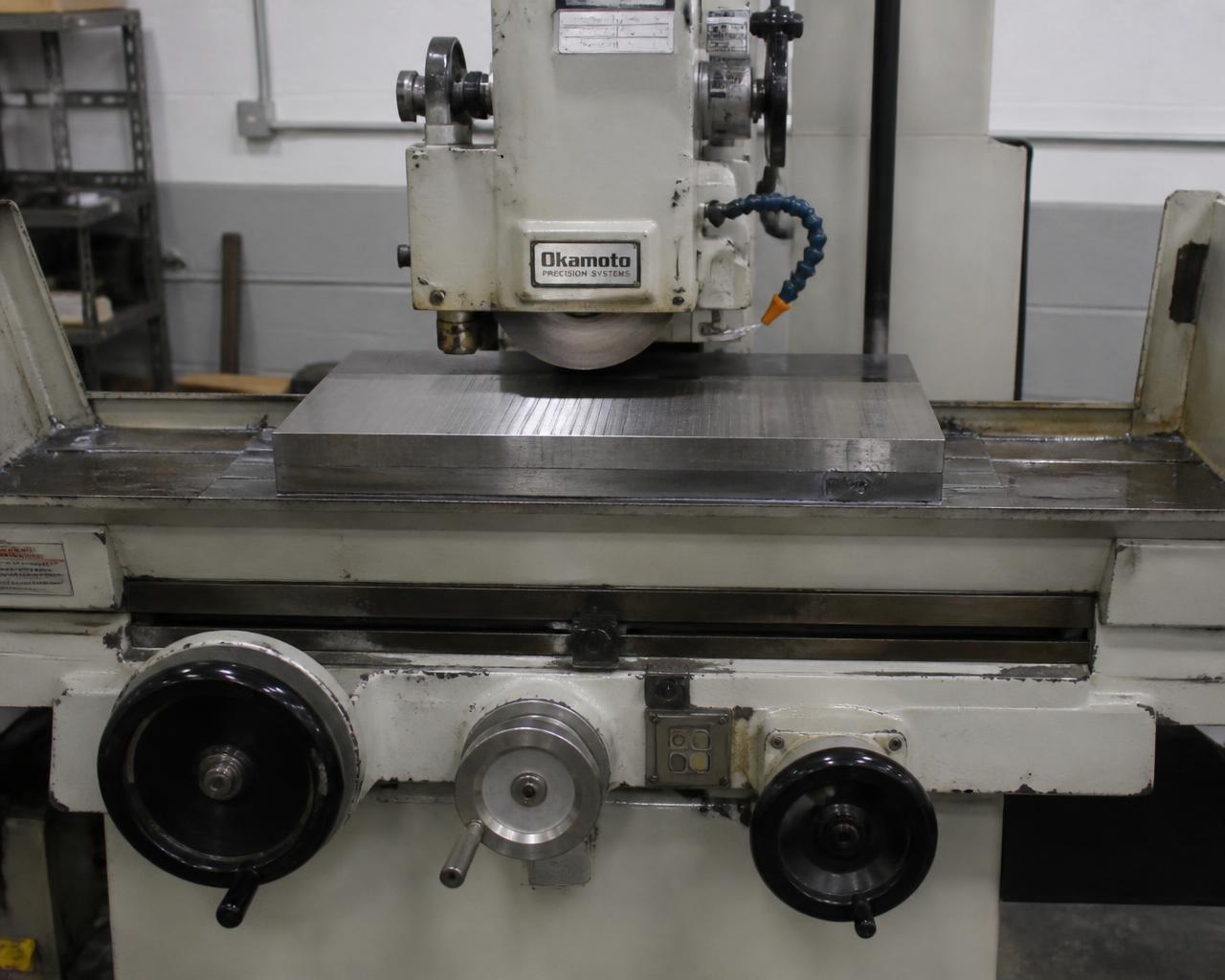 Surface grinder wheel passing over a steel plate held on a magnetic chuck